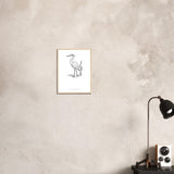 Heron line art framed print on a pale plaster wall above a desk lamp
