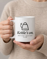 Kettle's On mug held in two hands